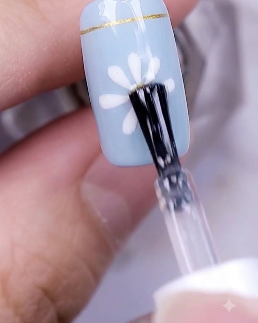 Une main avec un design dongle marguerite terminé catalysant sous une lampe à ongles UV professionnelle.