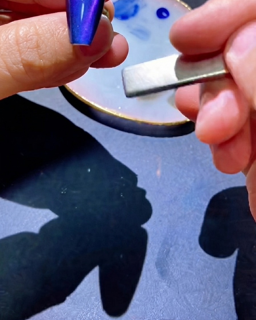 Un aimant utilisé le long de longle pour attirer les pigments en une ligne centrée.