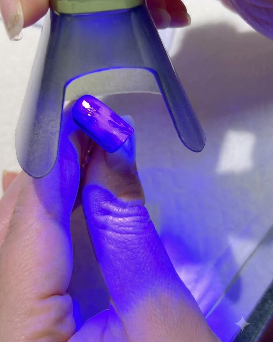 Une lampe UV violette catalysant les détails des feuilles vert clair sur un ongle peint.