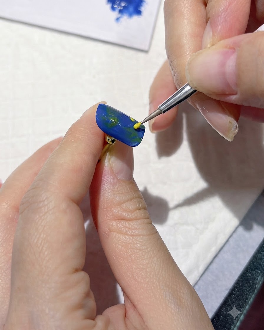 Un outil de détail fin appliquant des points jaunes pour marquer les centres des fleurs sur un ongle bleu.