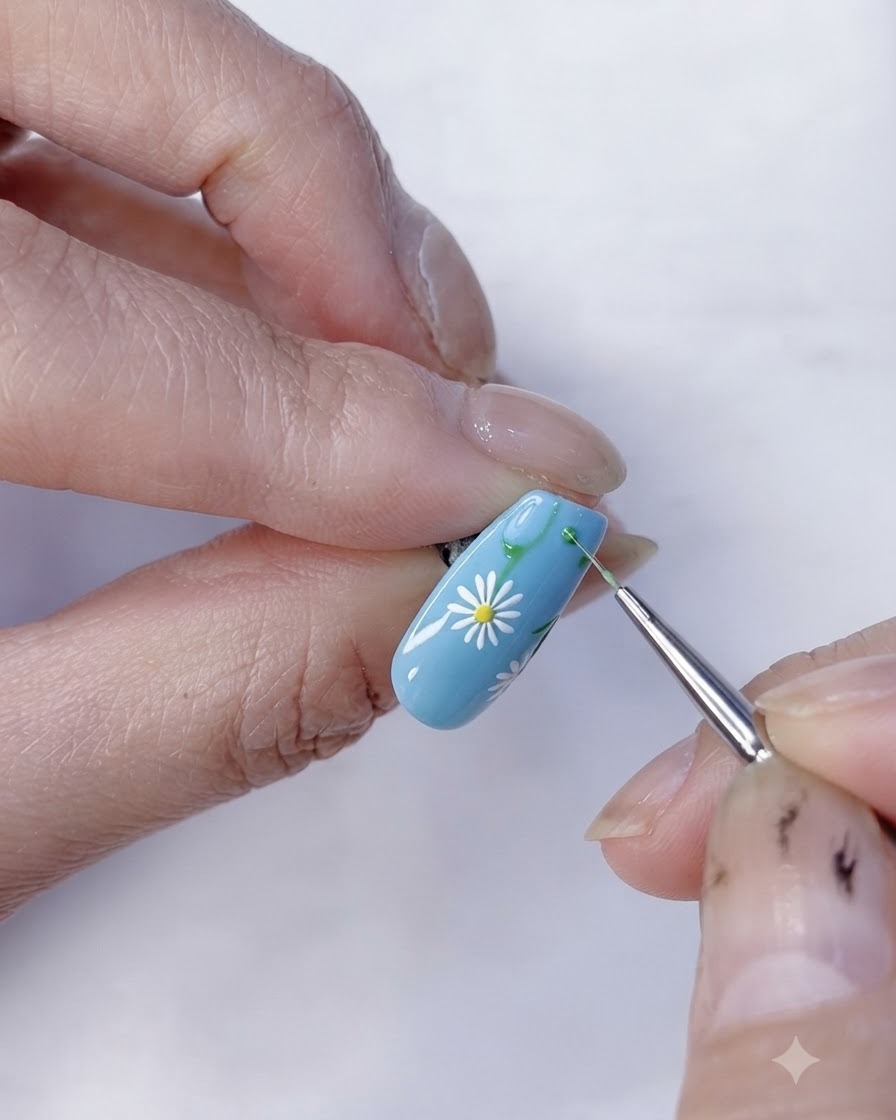 Vue rapprochée dun nail art marguerite floral achevé sur une base bleu clair.