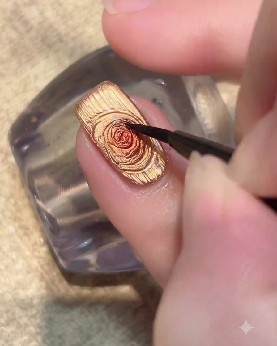 Un ongle éclairé sous une lampe UV LED faisant durcir la couche de vernis gel œil-de-chat doré.