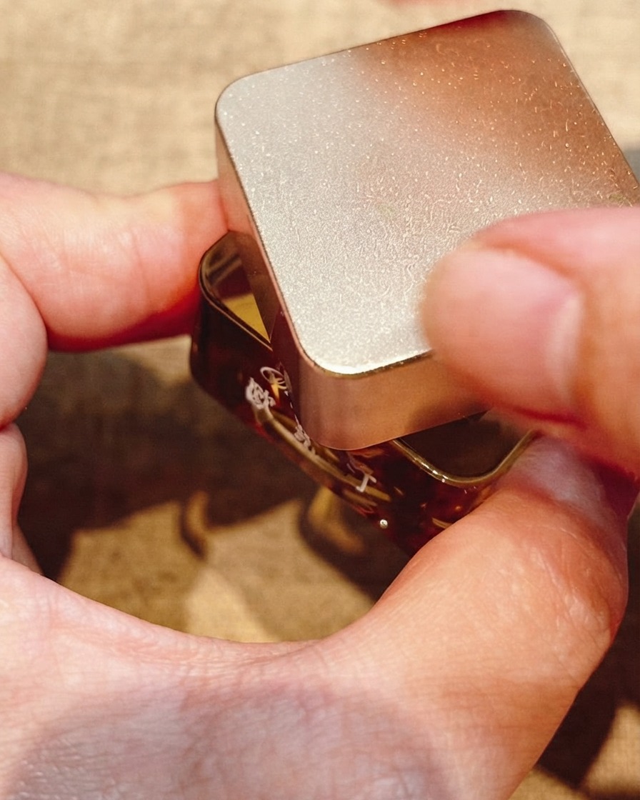 Gros plan sur un pinceau à nail art fin traçant des cercles concentriques sur un design dongle en gel.