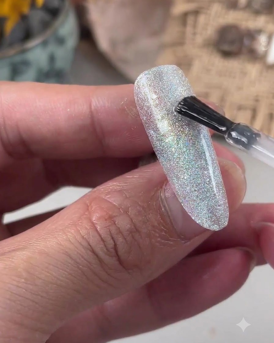 Un pinceau appliquant du gel de nivellement transparent sur une surface dongle pailletée.