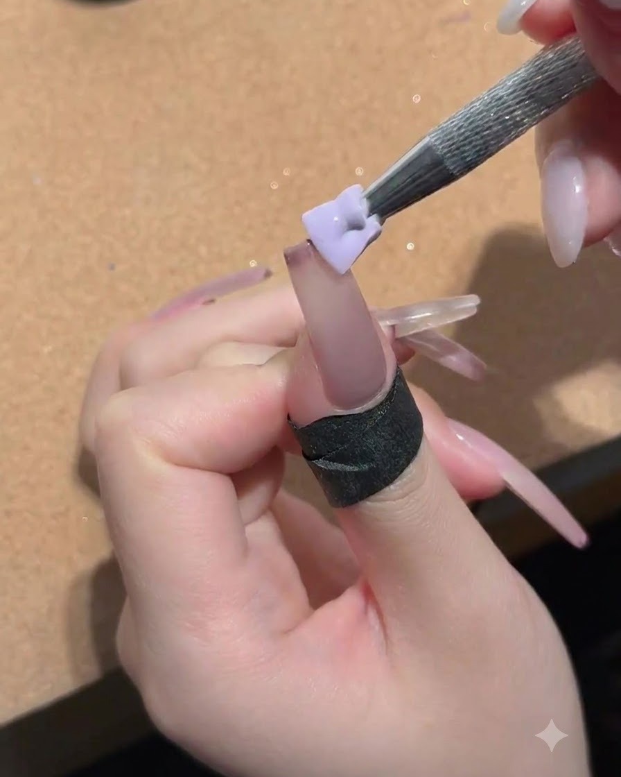 Une petite éponge tenue par un outil métallique tapotant du gel pêche nud sur la surface de longle.