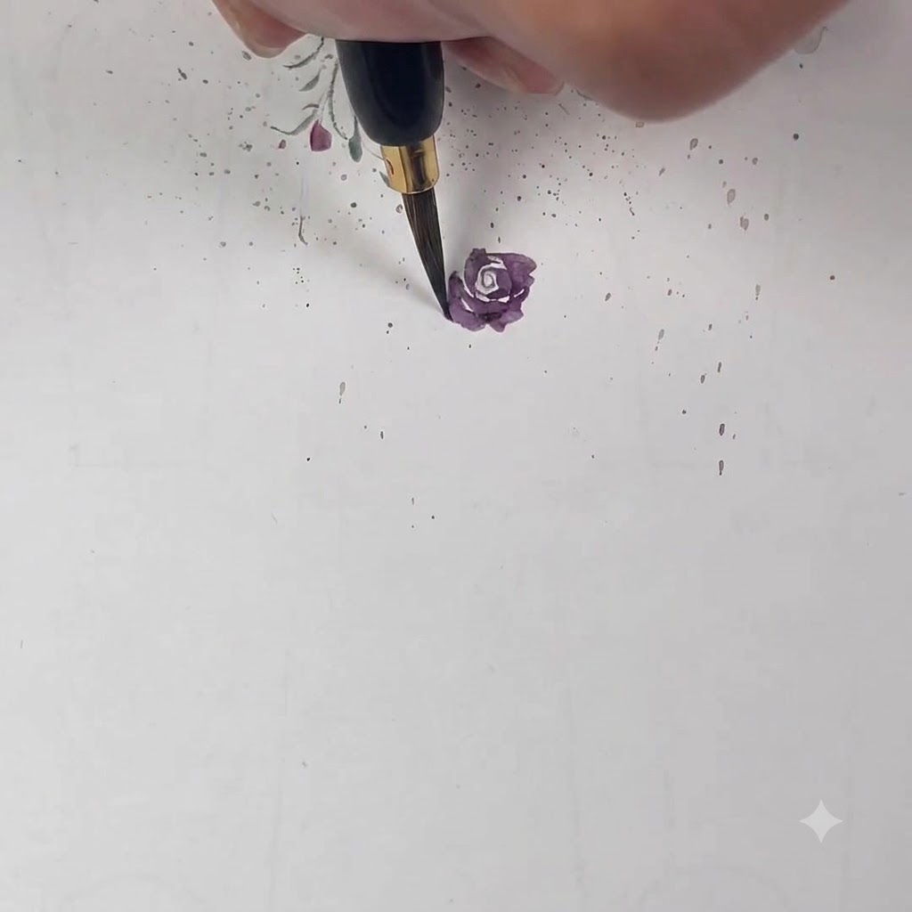 Un pinceau fin déposant un pétale violet clair qui chevauche à moitié la couche précédente.