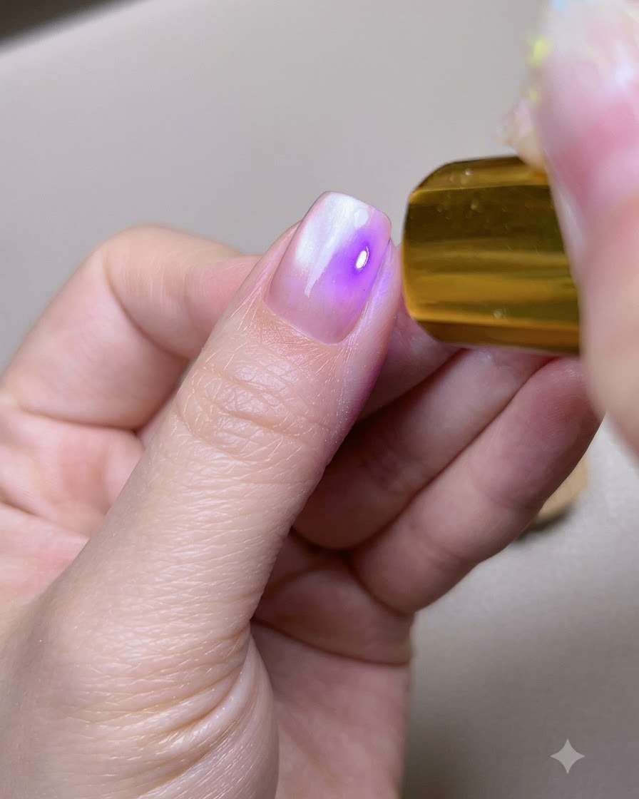 Un ongle de pouce placé sous une lampe de catalysation UV LED portable dorée.
