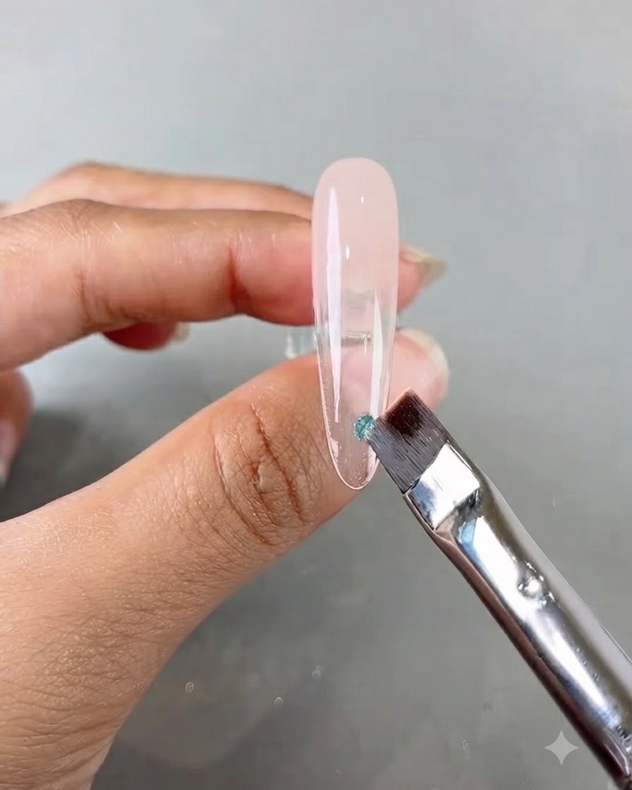 Un pinceau à ongles appliquant un petit morceau de sequin bleu sur un long ongle dentraînement transparent.