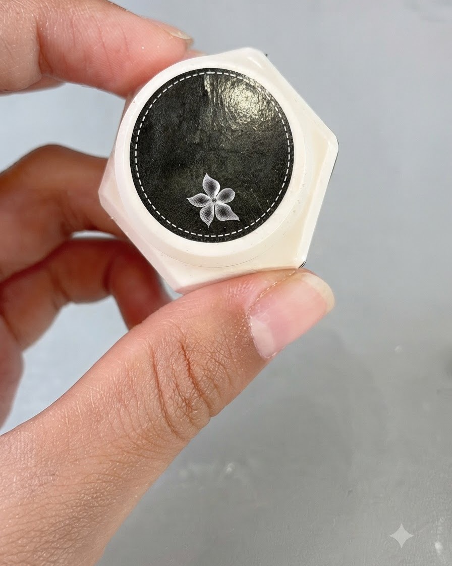 Un pot de gel de sculpture transparent avec une icône de fleur décorative sur le couvercle.