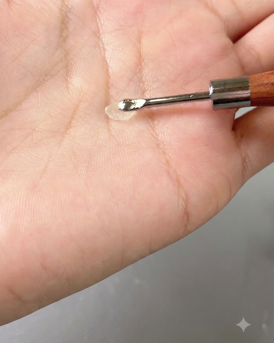 Une petite noisette de gel transparent reposant sur un outil à main contre la paume.