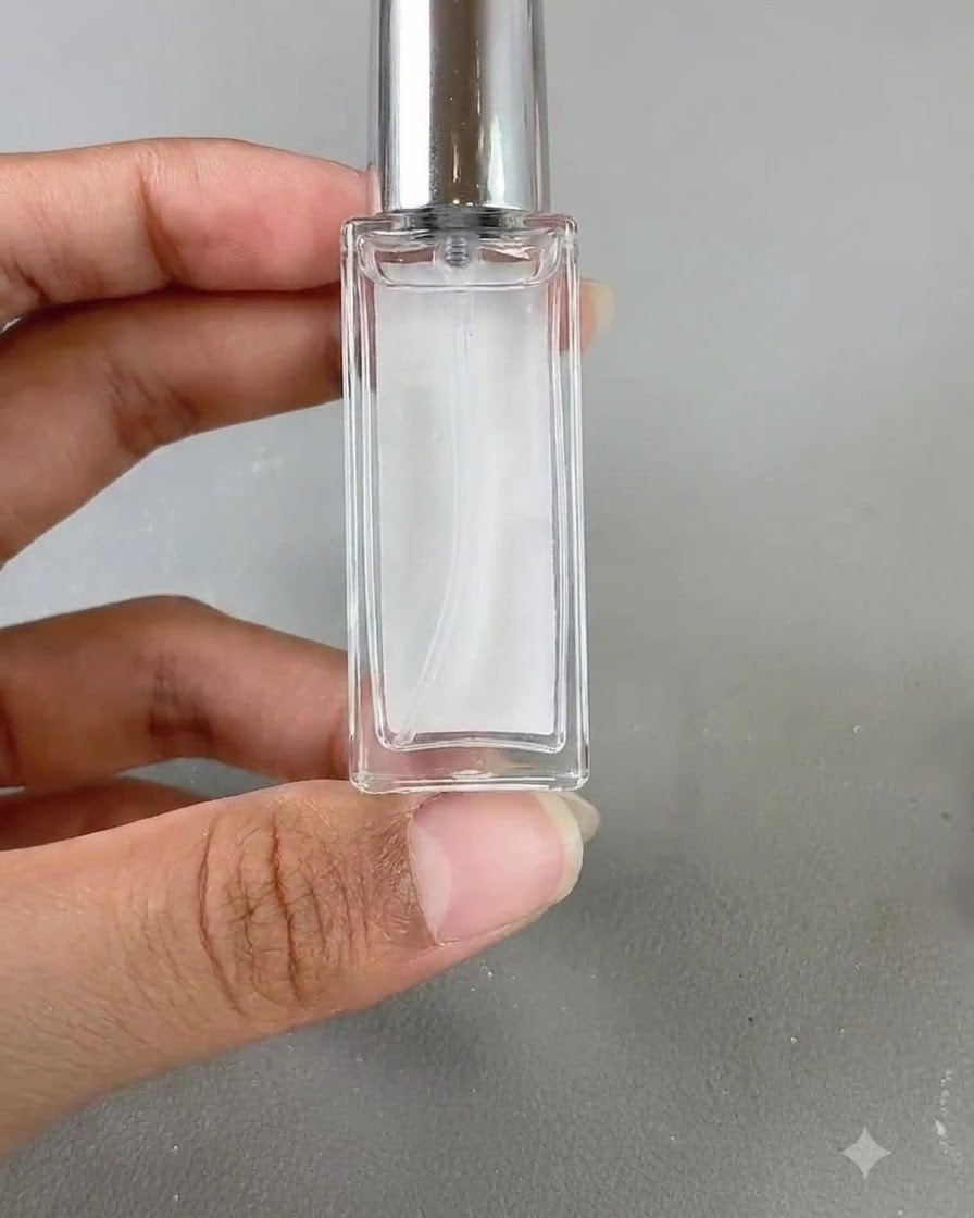 Un petit flacon en verre de liquide blooming tenu contre un fond neutre.