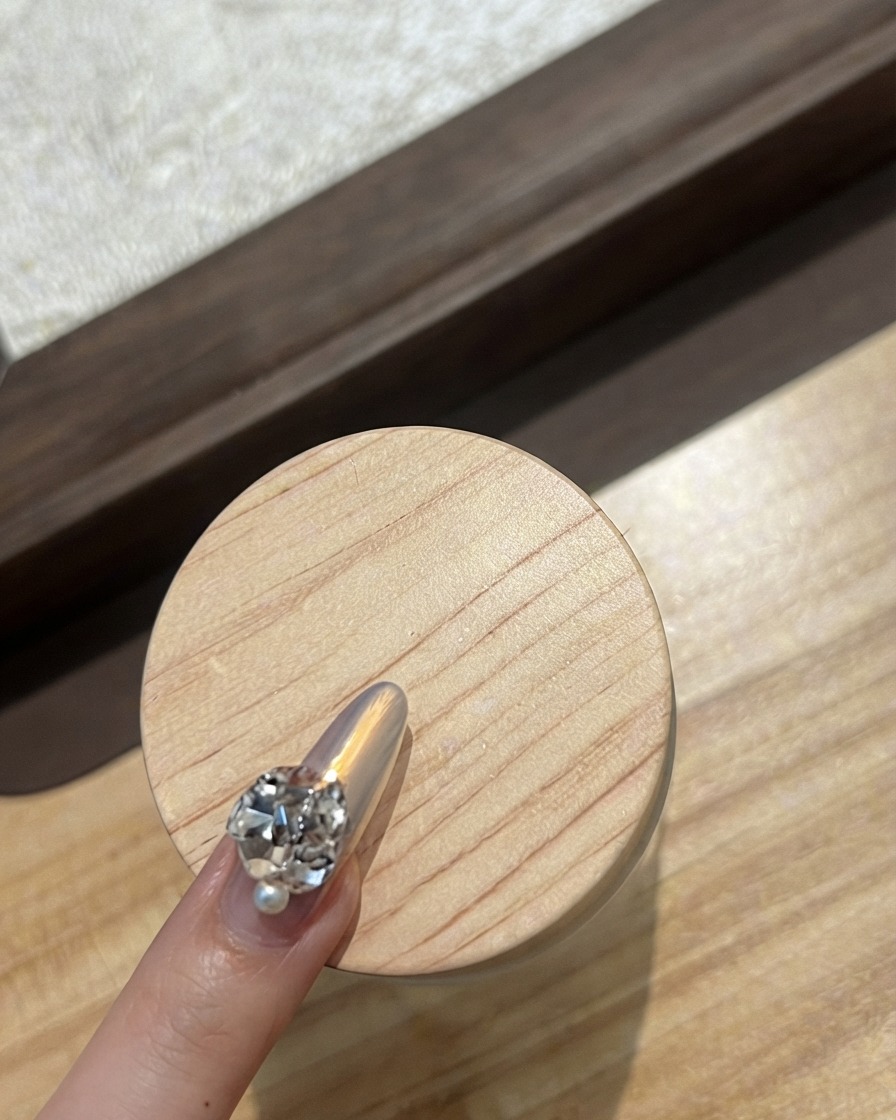 Gros plan dun ongle dindex décoré dune rangée incurvée de minuscules strass scintillants.