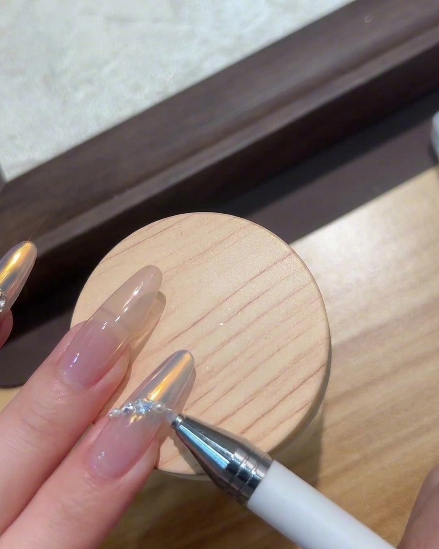 Des doigts placés sous une lampe UV/LED compacte pour polymériser les bijoux de nail art.
