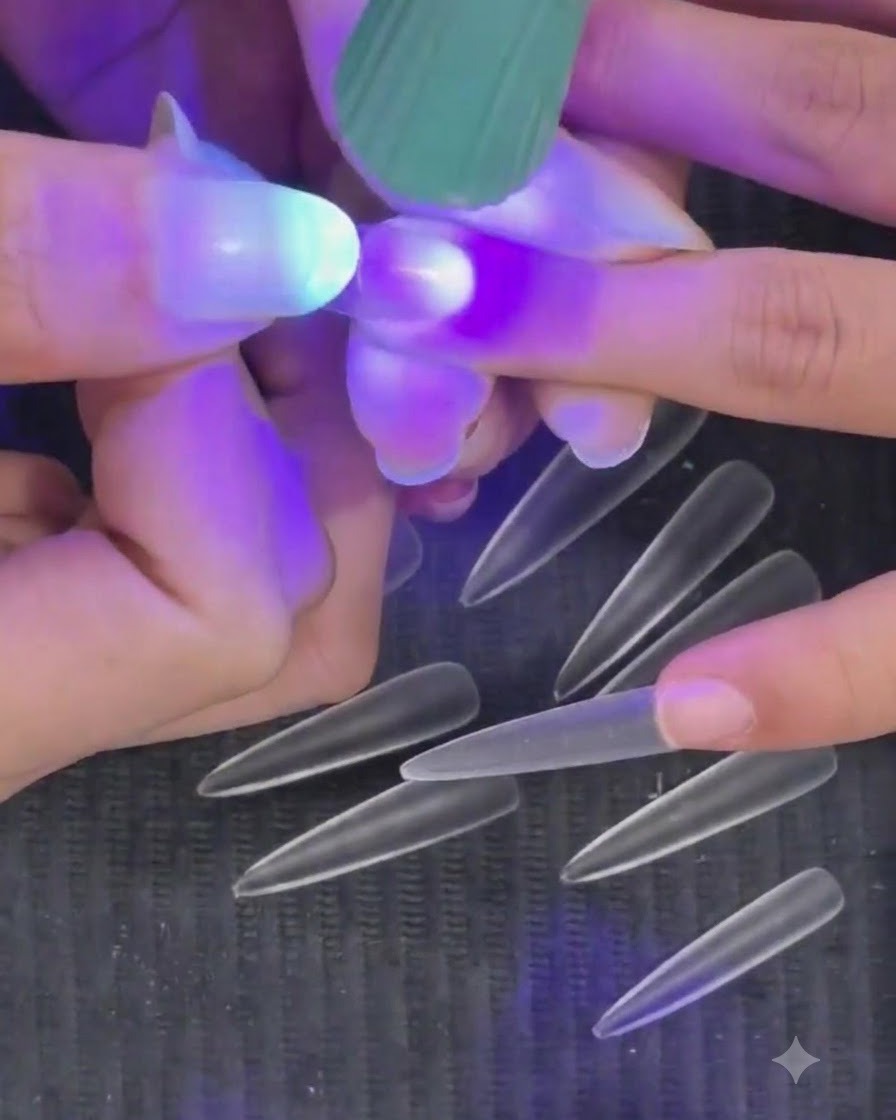 Main tenant une mini lampe de poche UV LED violette au-dessus dun ongle pour catalyser une capsule dongle semi-permanente.