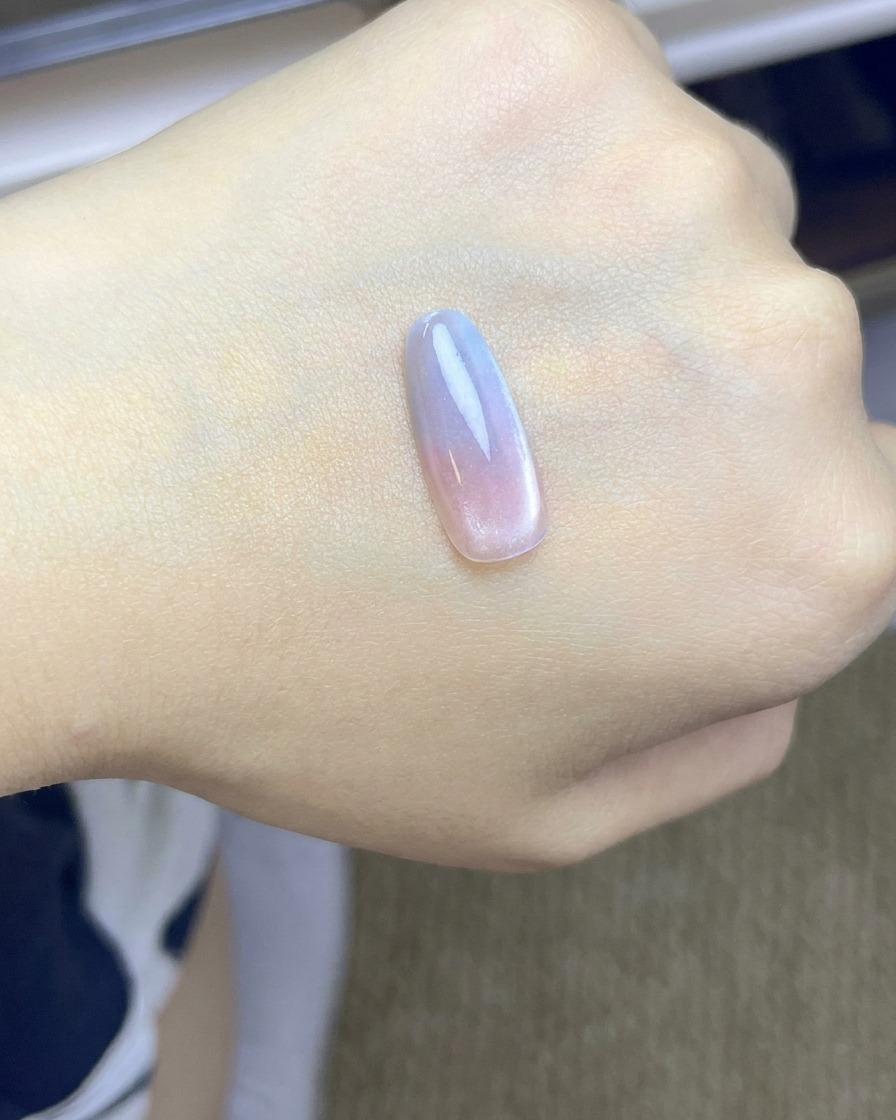 Une capsule dongle avec un dégradé blush rose en cours de catalysation sous une lampe UV/LED.
