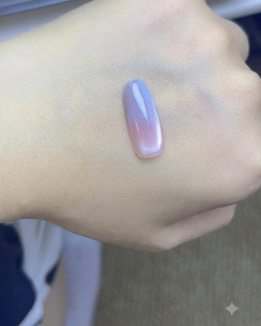Un pinceau tapotant une seconde couche de gel bleu sur le bout de longle dune main.