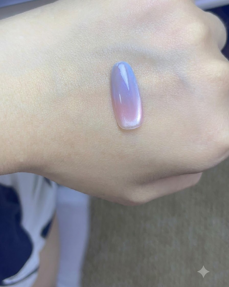 Une main avec des ongles cat-eye dégradés finis en cours de catalysation sous une lampe à ongles UV professionnelle.