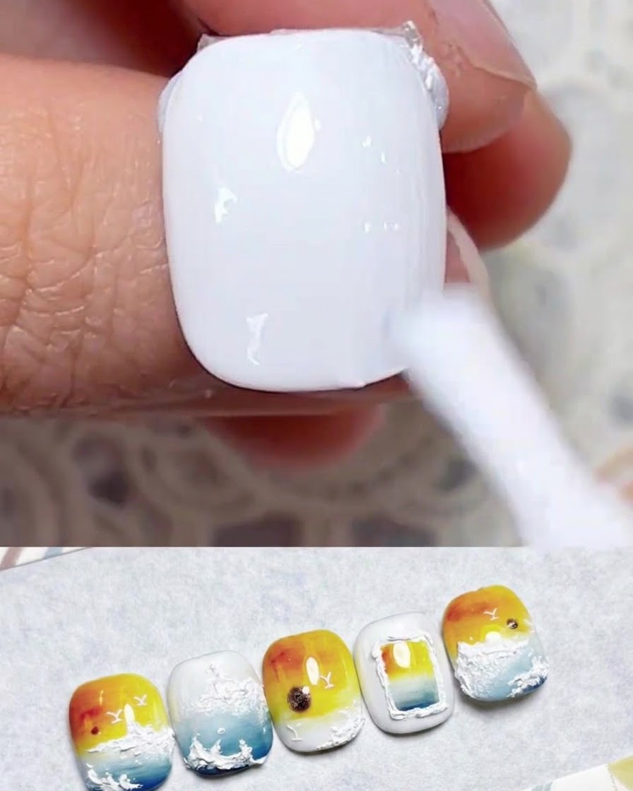 Un pinceau à ongle appliquant une couche lisse de vernis gel blanc laiteux sur un ongle naturel.