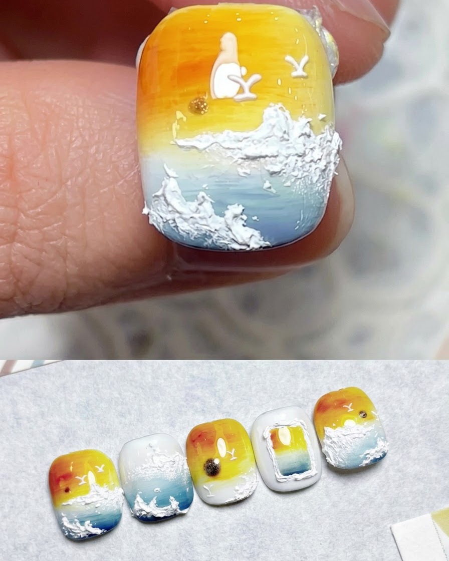 Un pinceau appliquant un top coat sur un design dongle fini en dégradé coucher de soleil.