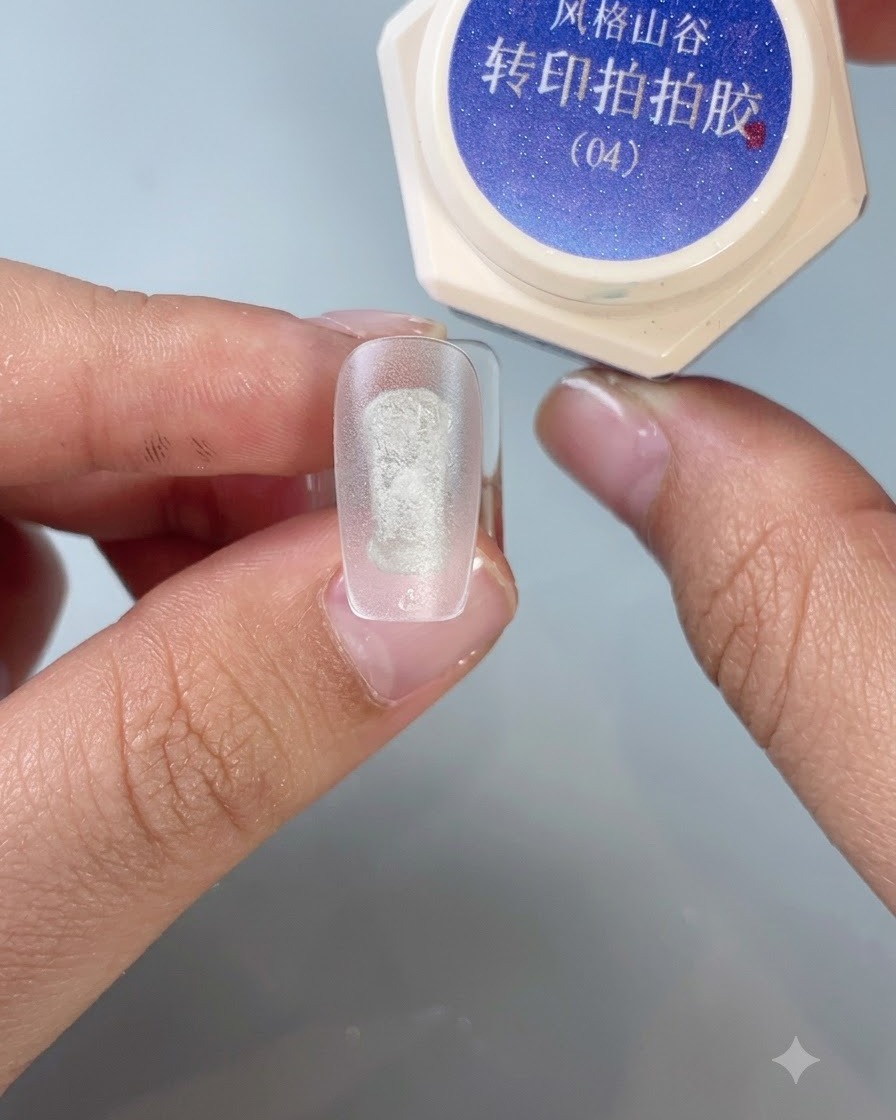 Un pinceau appliquant le gel de transfert pour stamping n° 4 au centre dun ongle dentraînement dépoli.