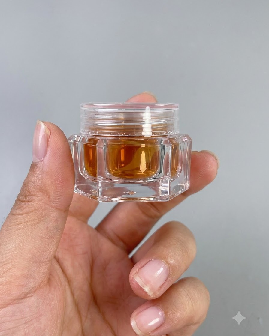 Un petit pot de gel effet verre ambré à haute transparence n° 9 tenu dans une main.
