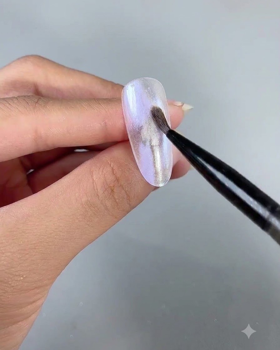 Un pinceau fin de nail art appliquant du gel nacré délicat numéro 3 sur la surface de longle.