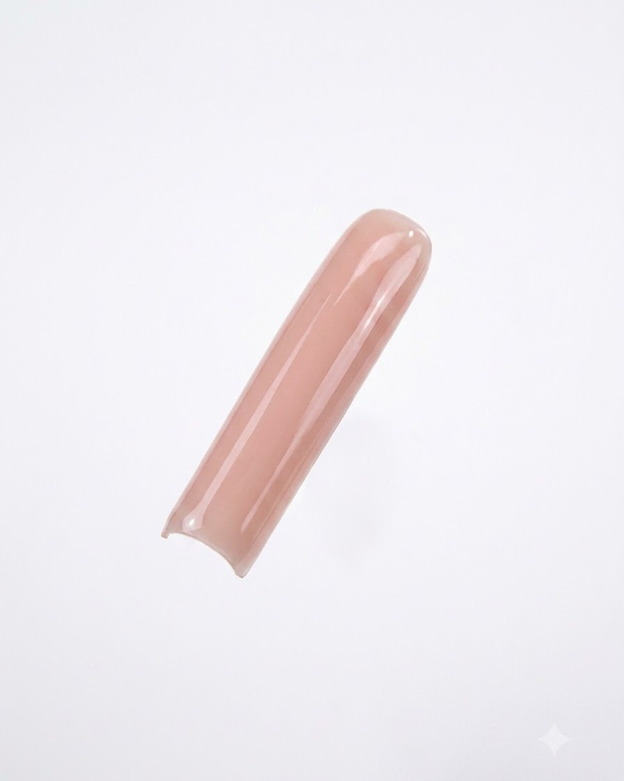 Une capsule dongle carrée longue peinte avec un vernis gel nude lisse et opaque sur fond blanc.