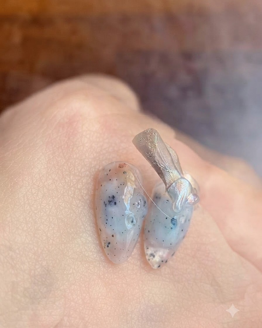 Gros plan dun pinceau appliquant une base gel transparente sur un ongle naturel.