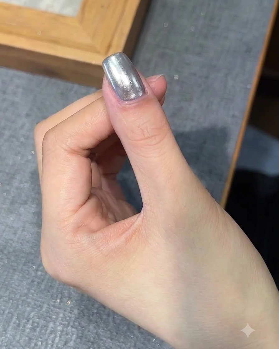Un pinceau appliquant une couche de gel de base sur longle fini au chrome.