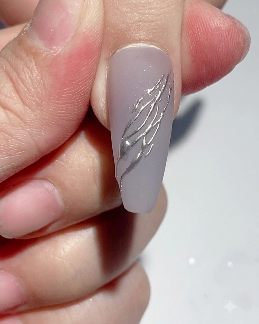 Pinceau liner déposant une goutte précise de colle transparente sur longle.