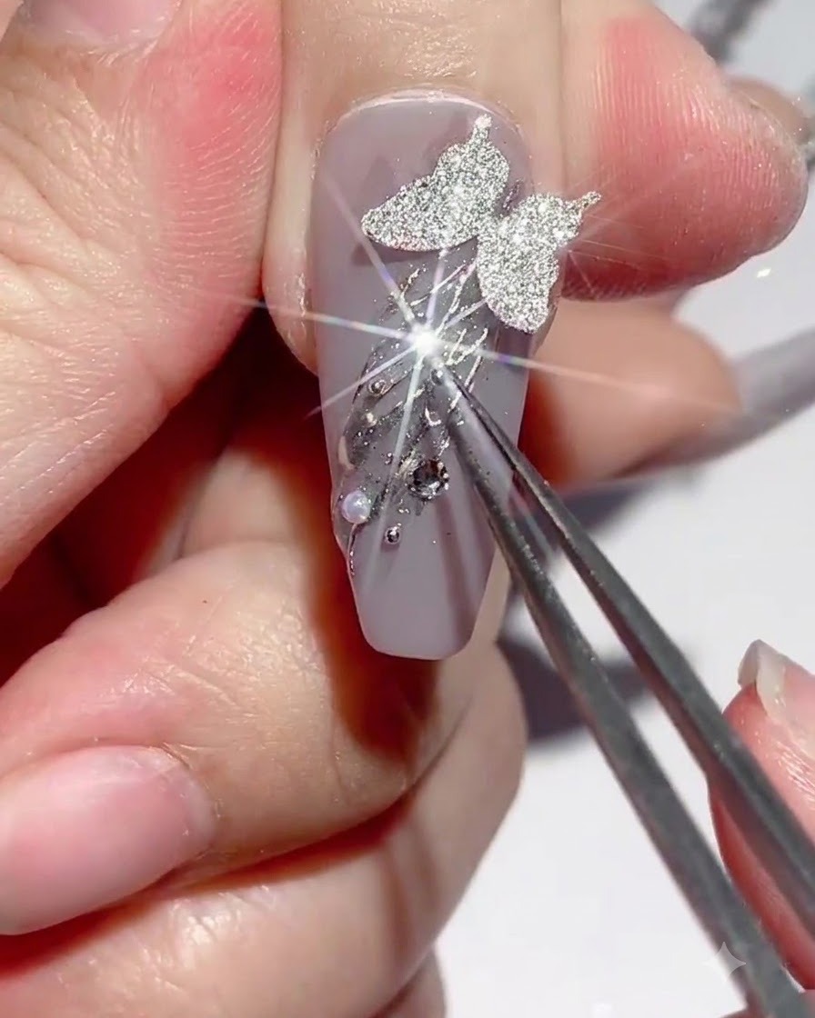 Pince brucelles maintenant un ornement tandis que du gel est appliqué autour des bordures.