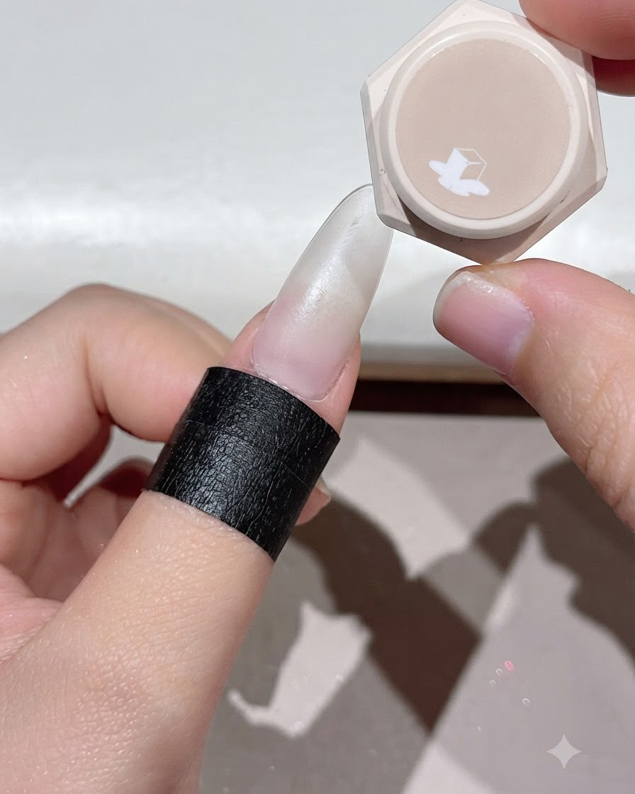 Un doigt placé sous une lampe à ongles UV ou LED pour catalyser la couche de gel appliquée.