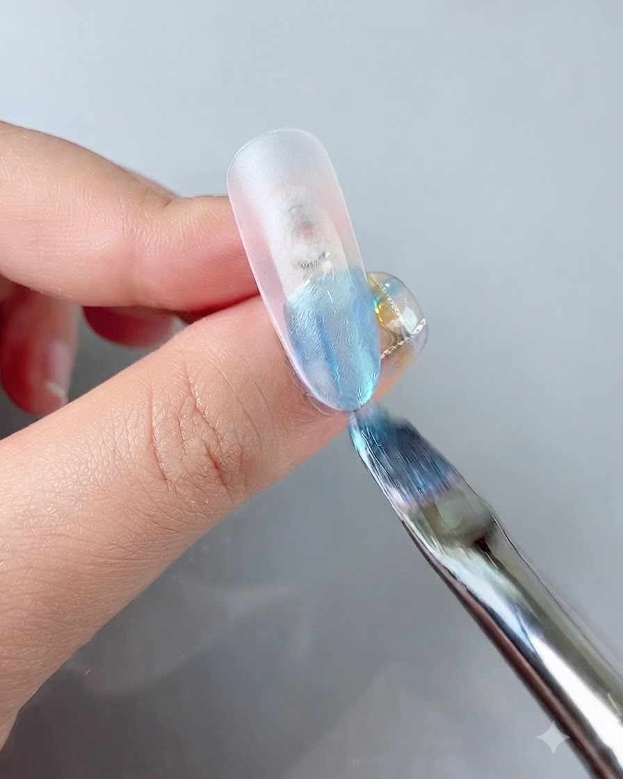 Un pinceau à ongle appliquant un gel de couleur bleu vibrant sur le bout dune extension dongle transparente.