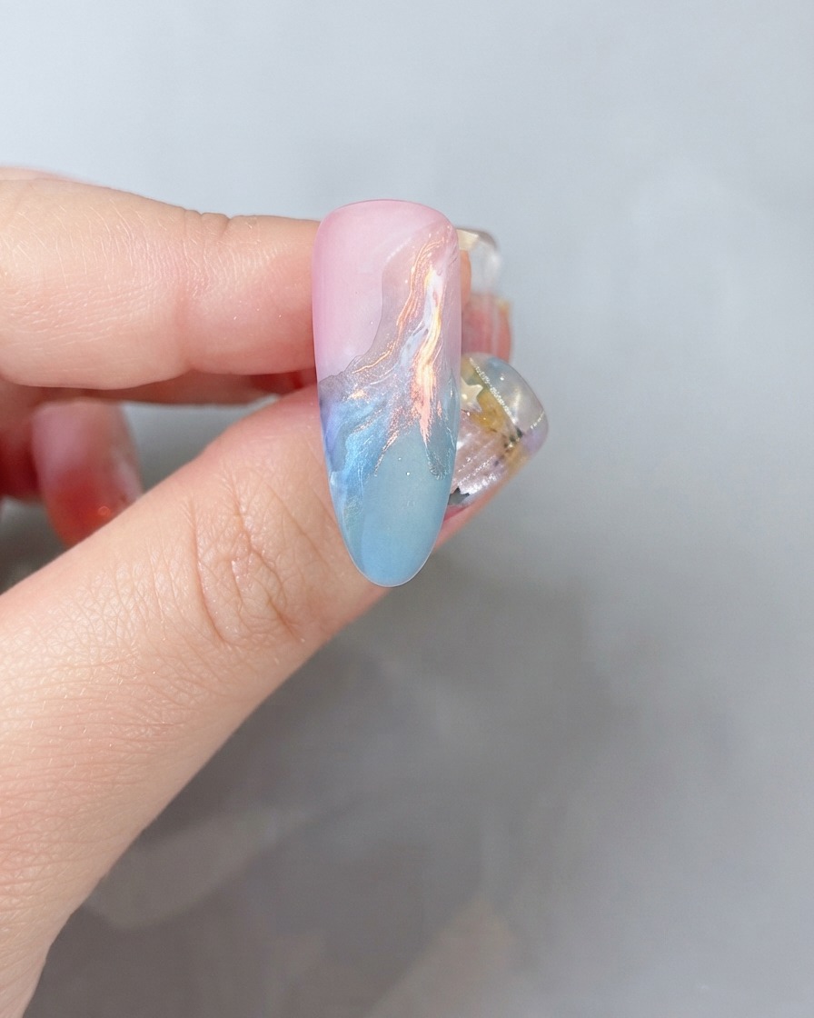 Une vue rapprochée de la surface dun ongle recevant un léger poudrage de poudre de paillettes colorées.