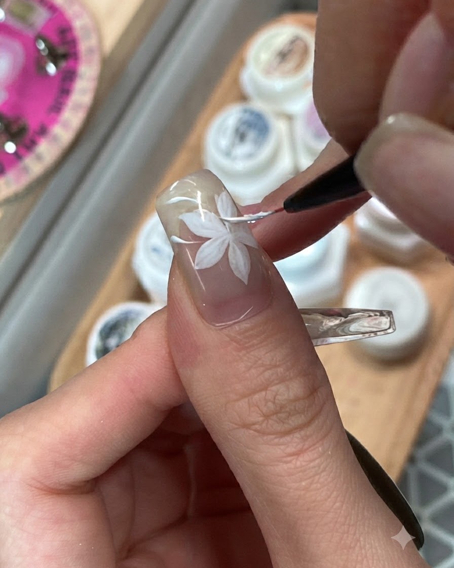 Un pinceau fin mélangeant des blocs de gel rose et violet adjacents sur longle dun annulaire.