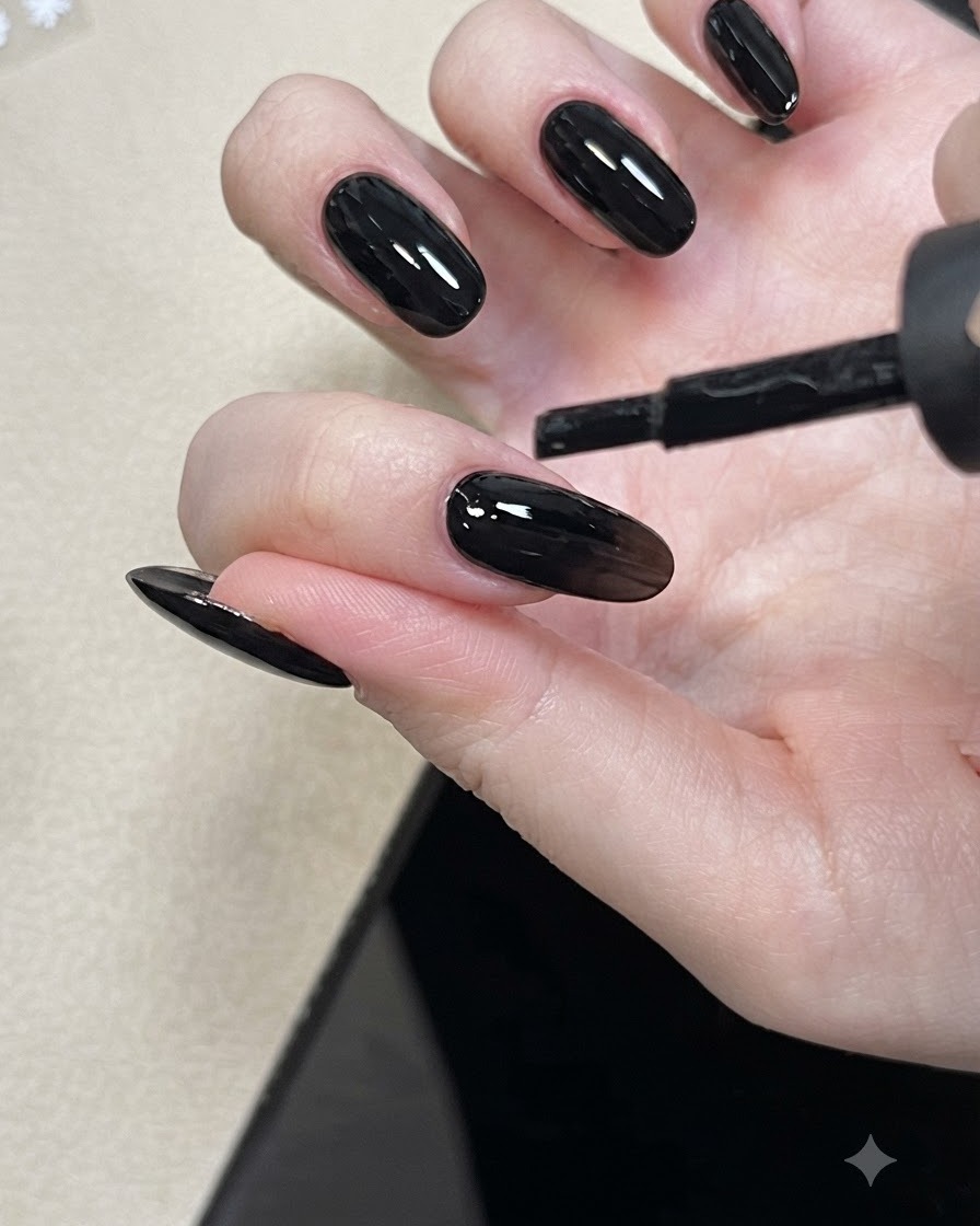 Un pinceau à ongle appliquant un gel de base nude sur un ongle.