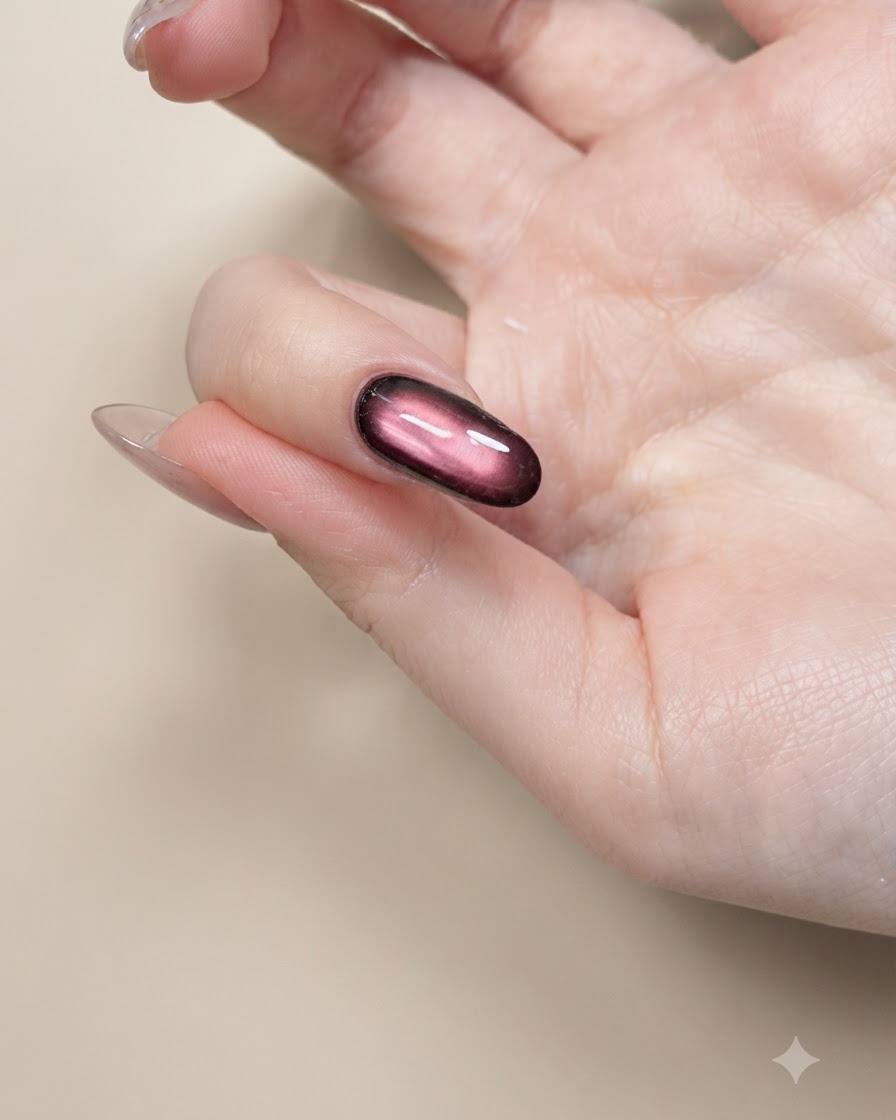 Un pinceau liner fin dessinant au noir les contours dailes de papillon sur un ongle nude.