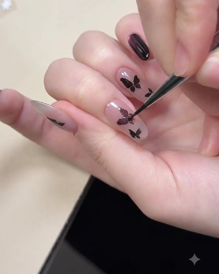 Un outil aimanté placé près dun ongle pour aimanter le reflet cat eye violet à lintérieur des formes de papillon noires.