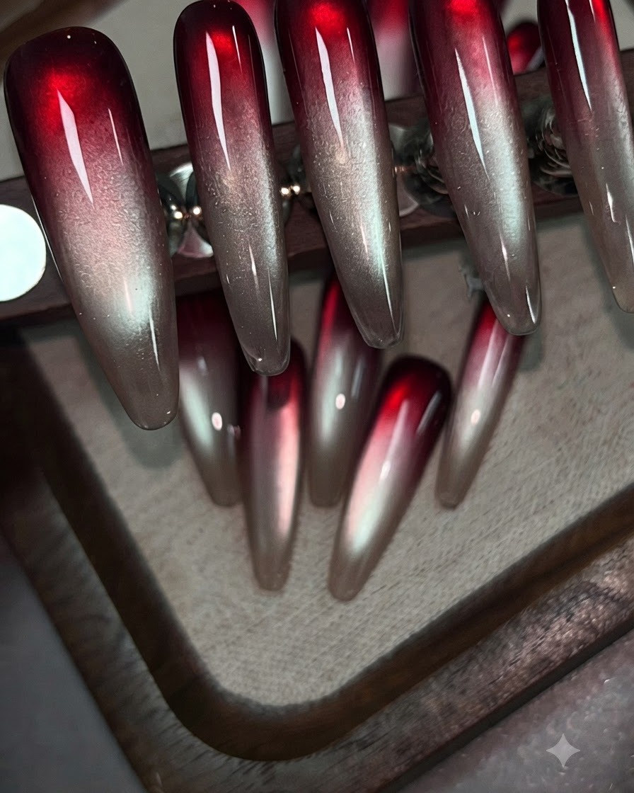 Un pinceau appliquant du gel rouge vin tapoté sur la partie supérieure dun ongle dentraînement transparent.