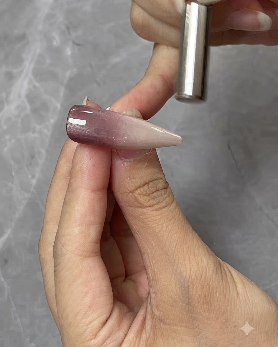 Un aimant cylindrique tenu de près au-dessus dune capsule dongle en gel cat-eye pour façonner la réflexion de la lumière magnétique.