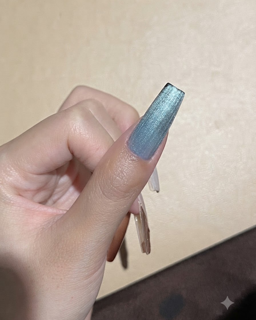 Un aimant puissant tenu près dun ongle en gel œil de chat bleu pour affiner la ligne de reflet de la lumière.