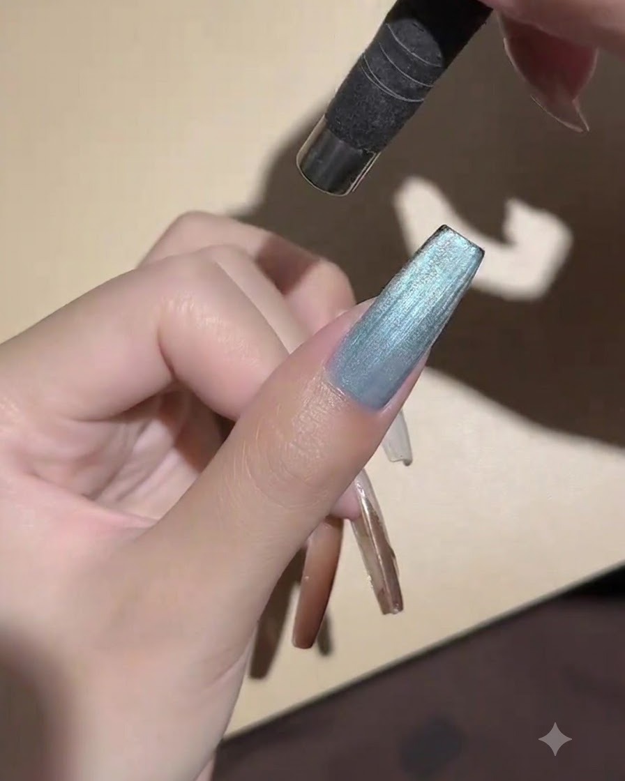 Une mini lampe UV LED portative positionnée directement au-dessus dun ongle peint pour figer le gel œil de chat.