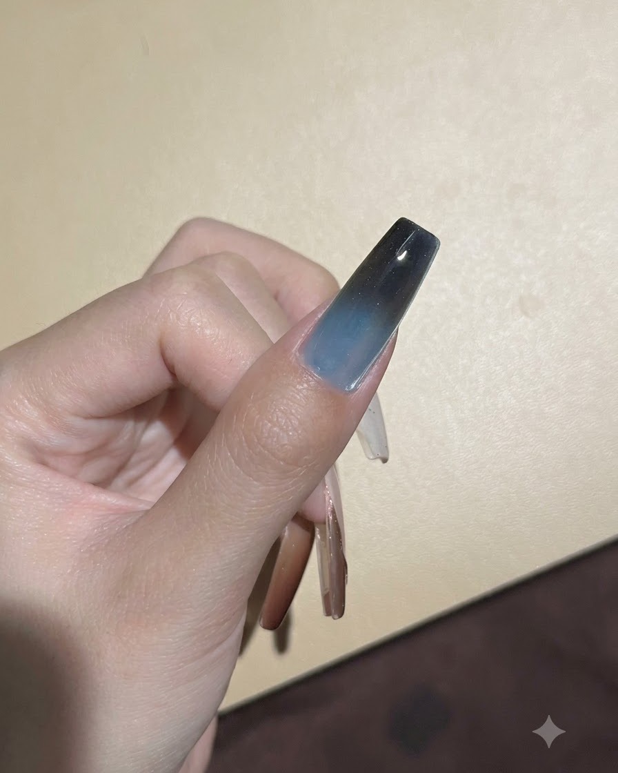 Une éponge tamponnant un pigment foncé sur le bord supérieur dun ongle en gel pour approfondir la transition ombrée.
