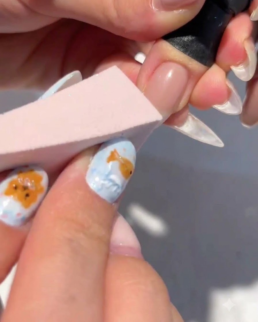 Une éponge de maquillage tamponnant du gel blanc sur le bout dun ongle pour former un dégradé.