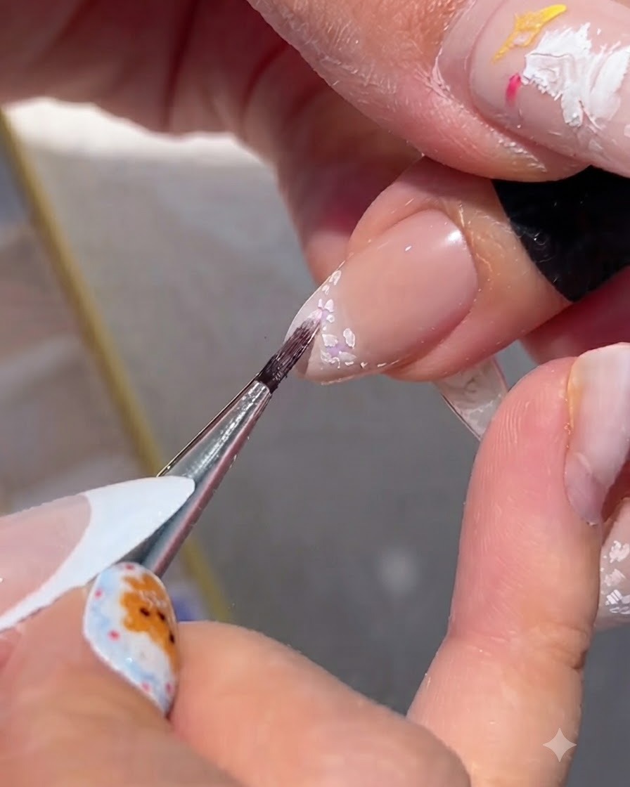 Un pinceau fin mélangeant des pigments de couleur doux dans les contours de fleurs blanches.