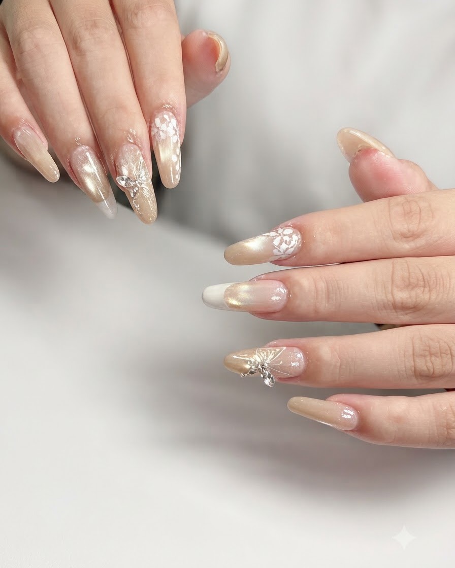 Prise de vue macro de longle de lannulaire présentant un nail art complexe de dentelle florale blanche sur une base dégradée nude.
