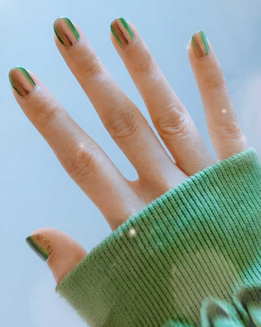Doigts écartés affichant des lignes ondulées abstraites détaillées et du vernis à ongles chrome réfléchissant.