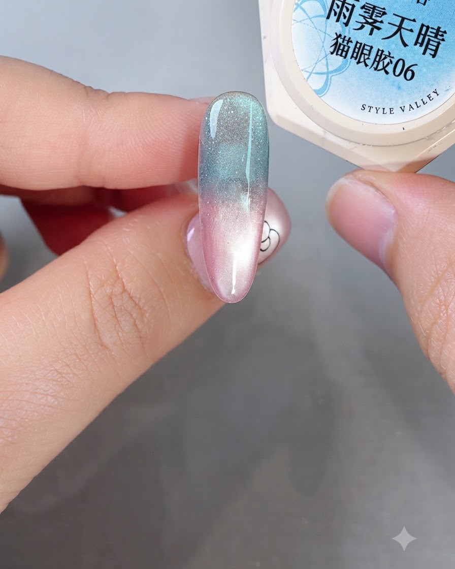 Un pinceau fin pour nail art appliquant du gel blanc laiteux auto-égalisant sur un ongle coloré en dégradé pour former des formes abstraites douces.