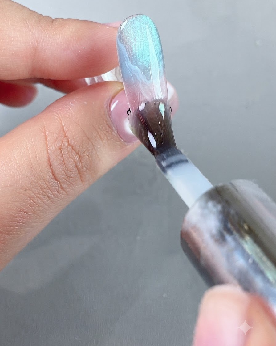 Un pinceau appliquant une couche lisse de top coat protecteur isolant sur la surface décorée de longle.