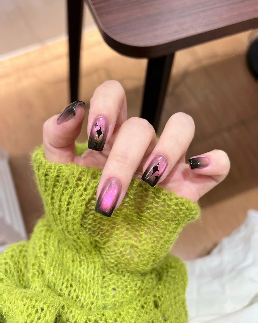 Application dune touche concentrée de gel noir foncé sur le bord dun ongle en dégradé.